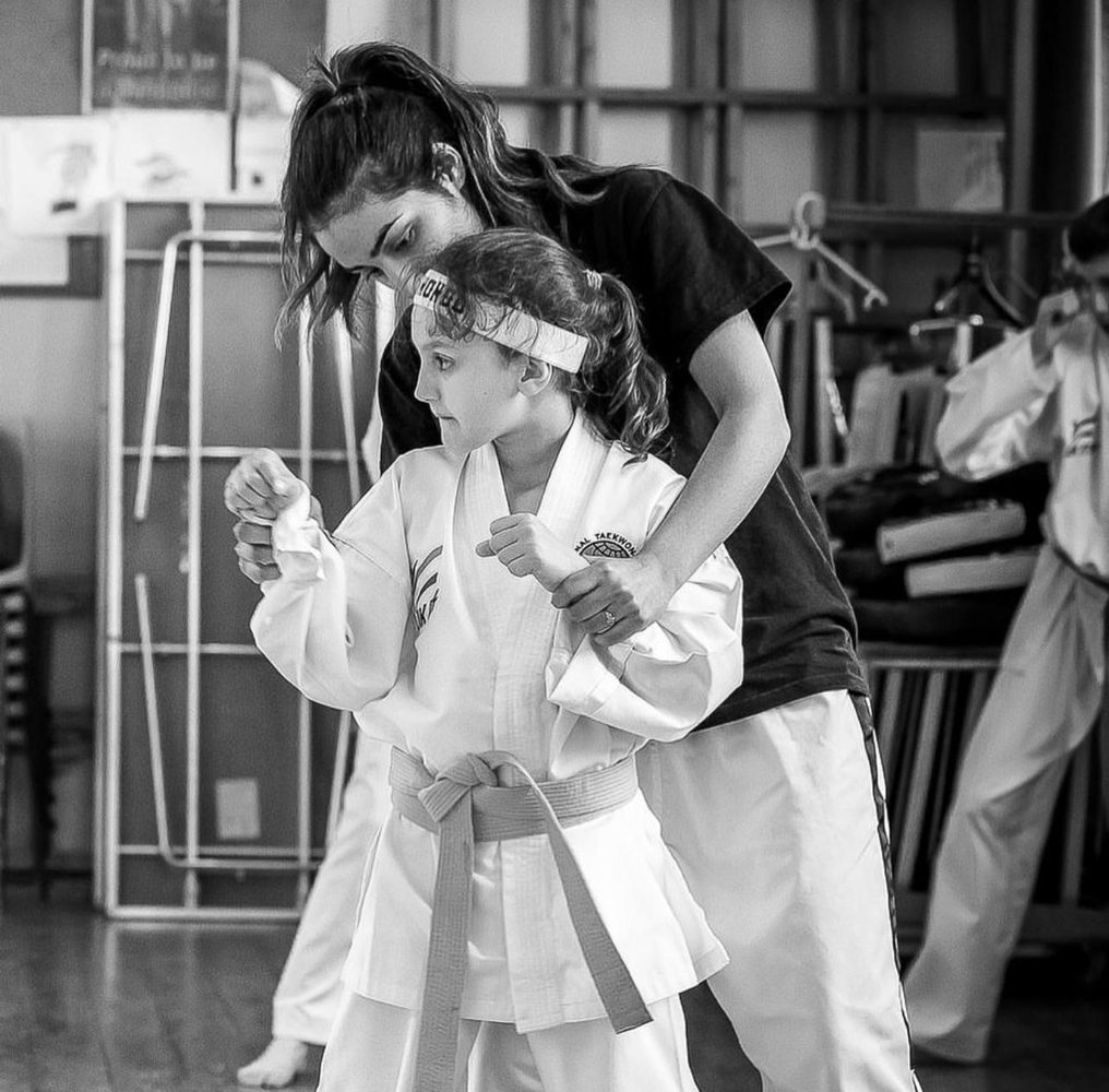Instructor guiding a young student’s technique